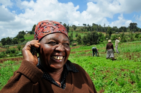 A Kenyan farmer uses a mobile phone in the field_Neil Palmer, CIAT, Flickr CC_ORIGINAL.jpg